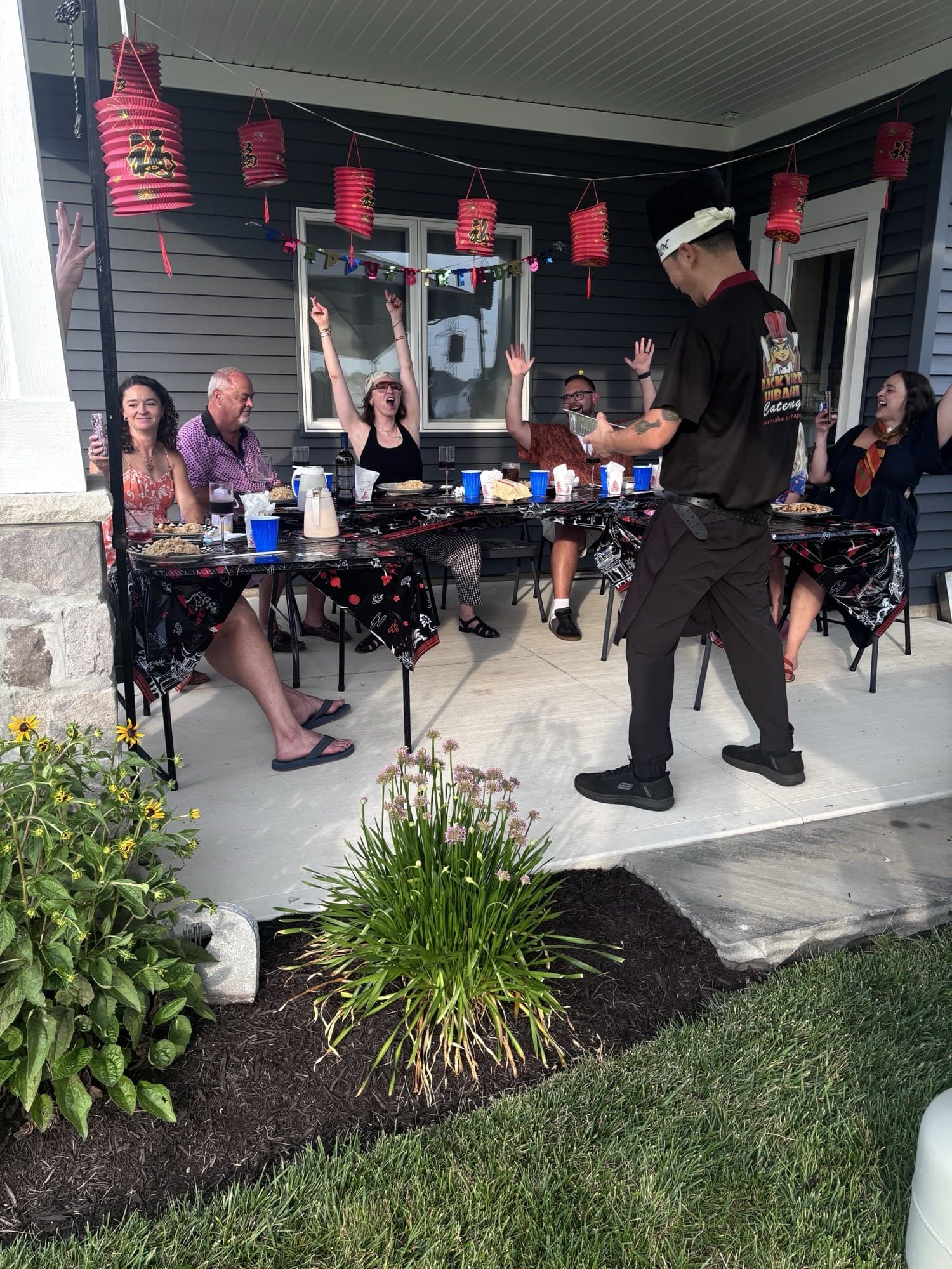 Backyard Hibachi chef performing for guests under string lanterns